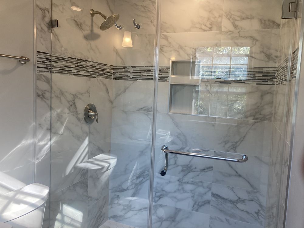 A bathroom with marble tiles and a walk in shower