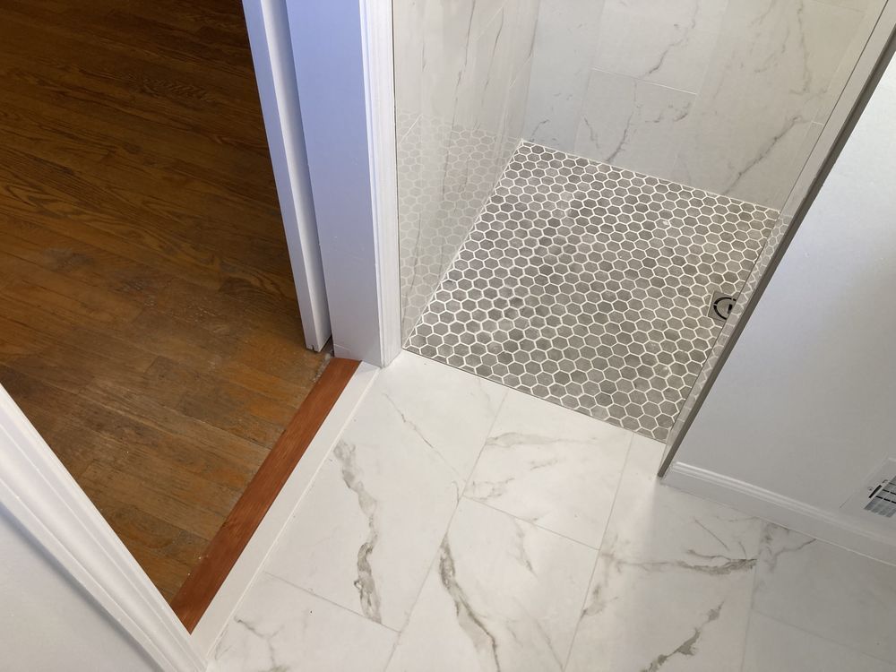 A bathroom with marble tiles and a walk in shower