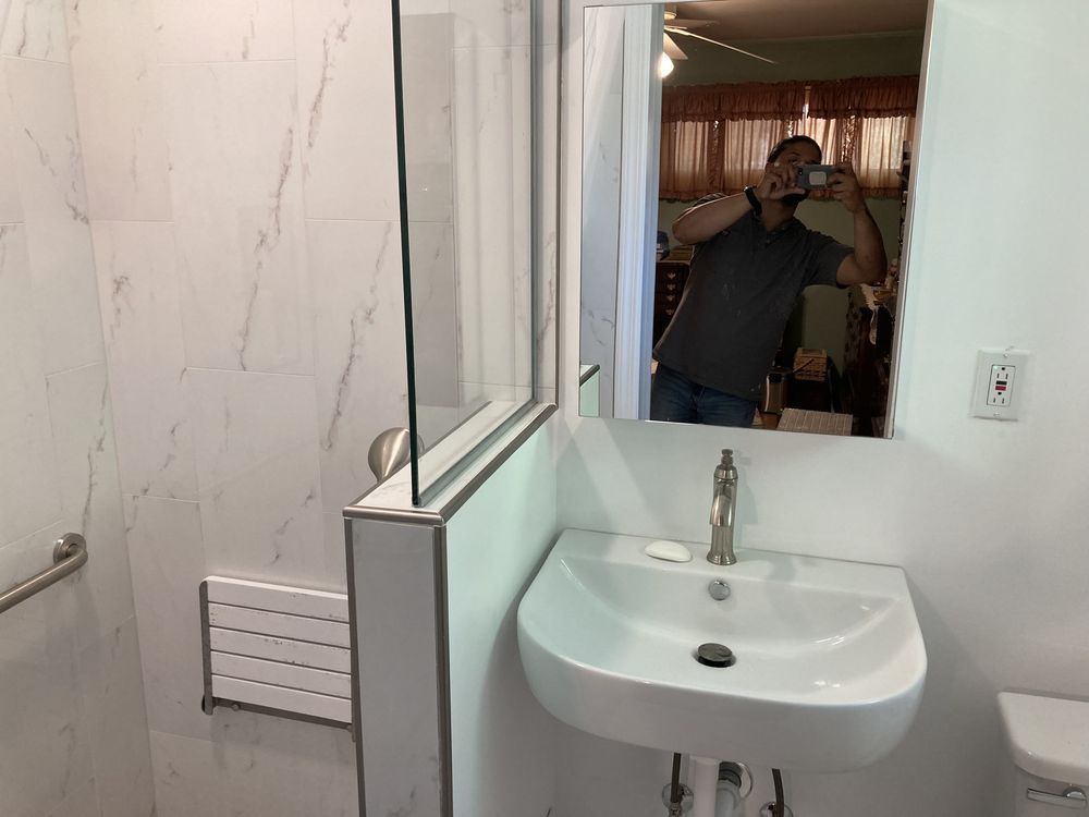 A man is taking a picture of himself in a bathroom mirror.