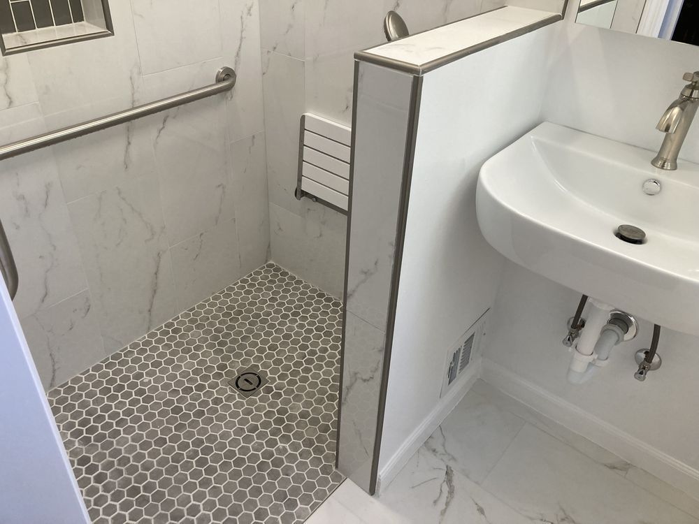 A bathroom with a sink and a walk in shower