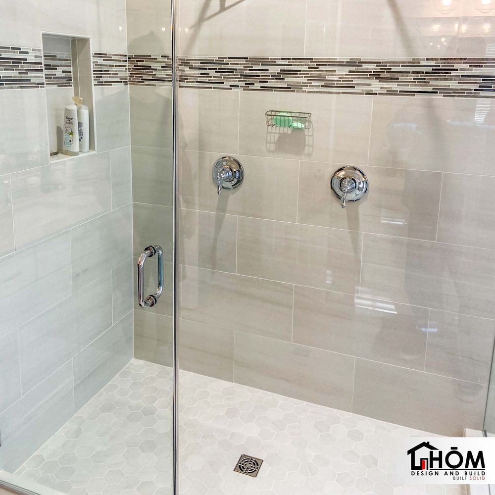 A shower with a glass door and a thom logo on the bottom
