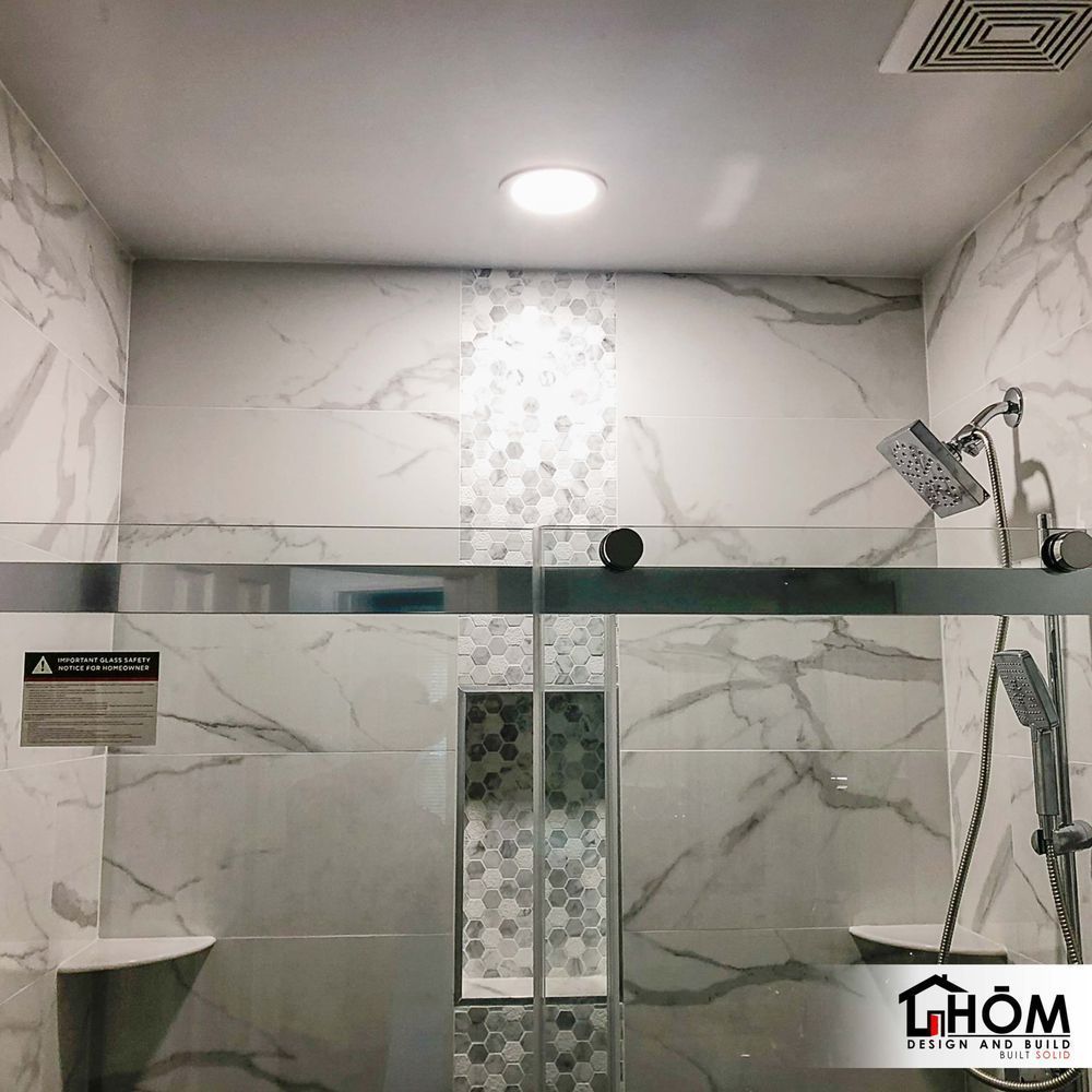 A bathroom with a sliding glass shower door and a shower head.