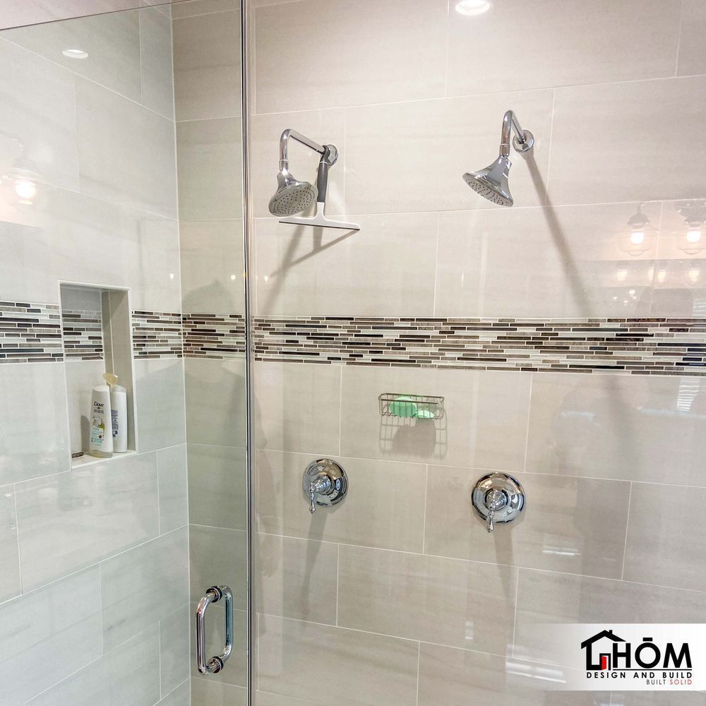 A shower with two shower heads and a sign that says thom