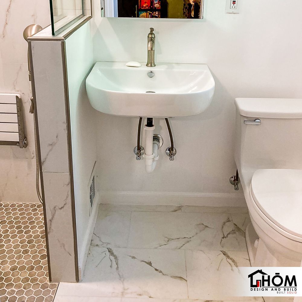 A bathroom with a sink and toilet and a thom logo