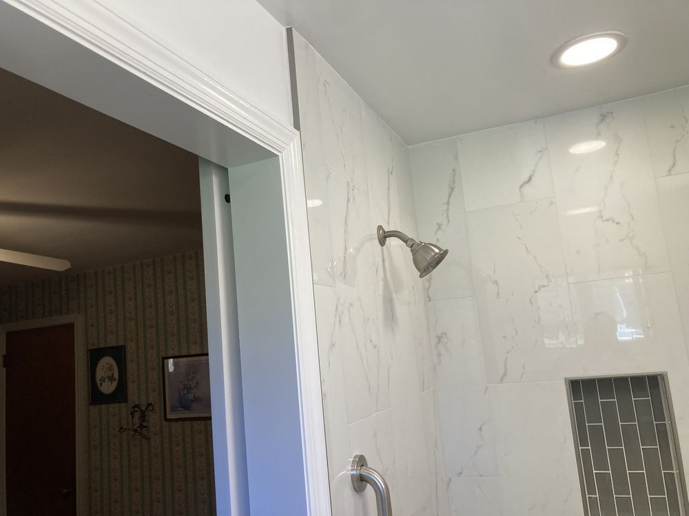 A shower head is hanging from the ceiling in a bathroom.