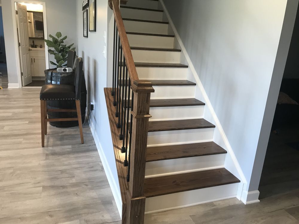 A staircase in a house with wooden steps and a metal railing.