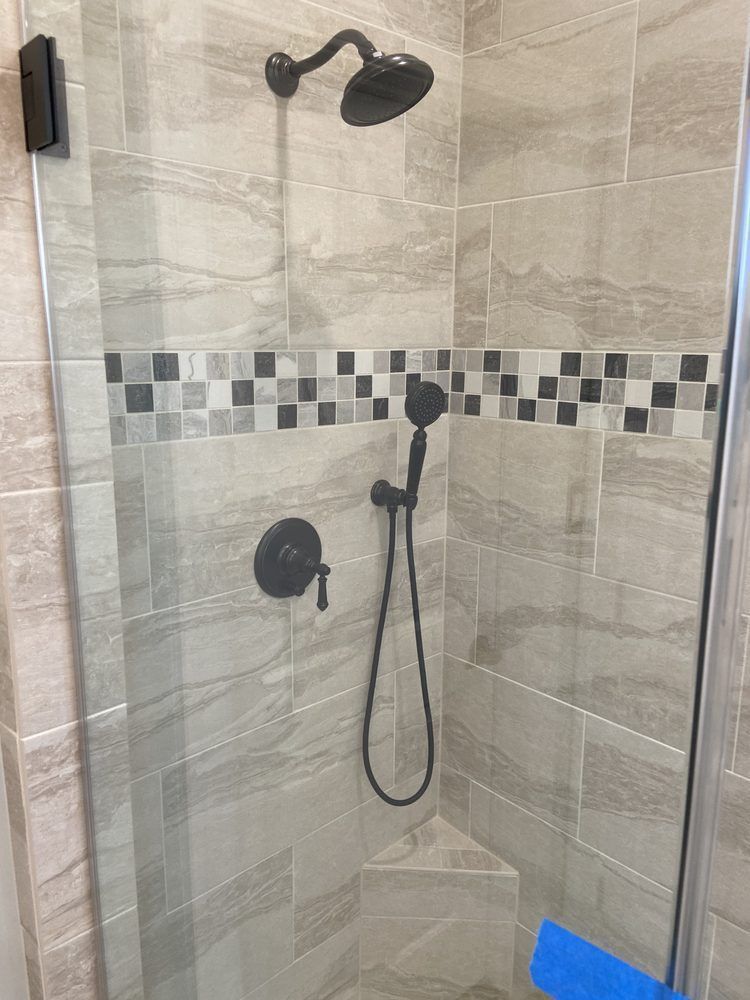 A shower with a glass door and a shower head.
