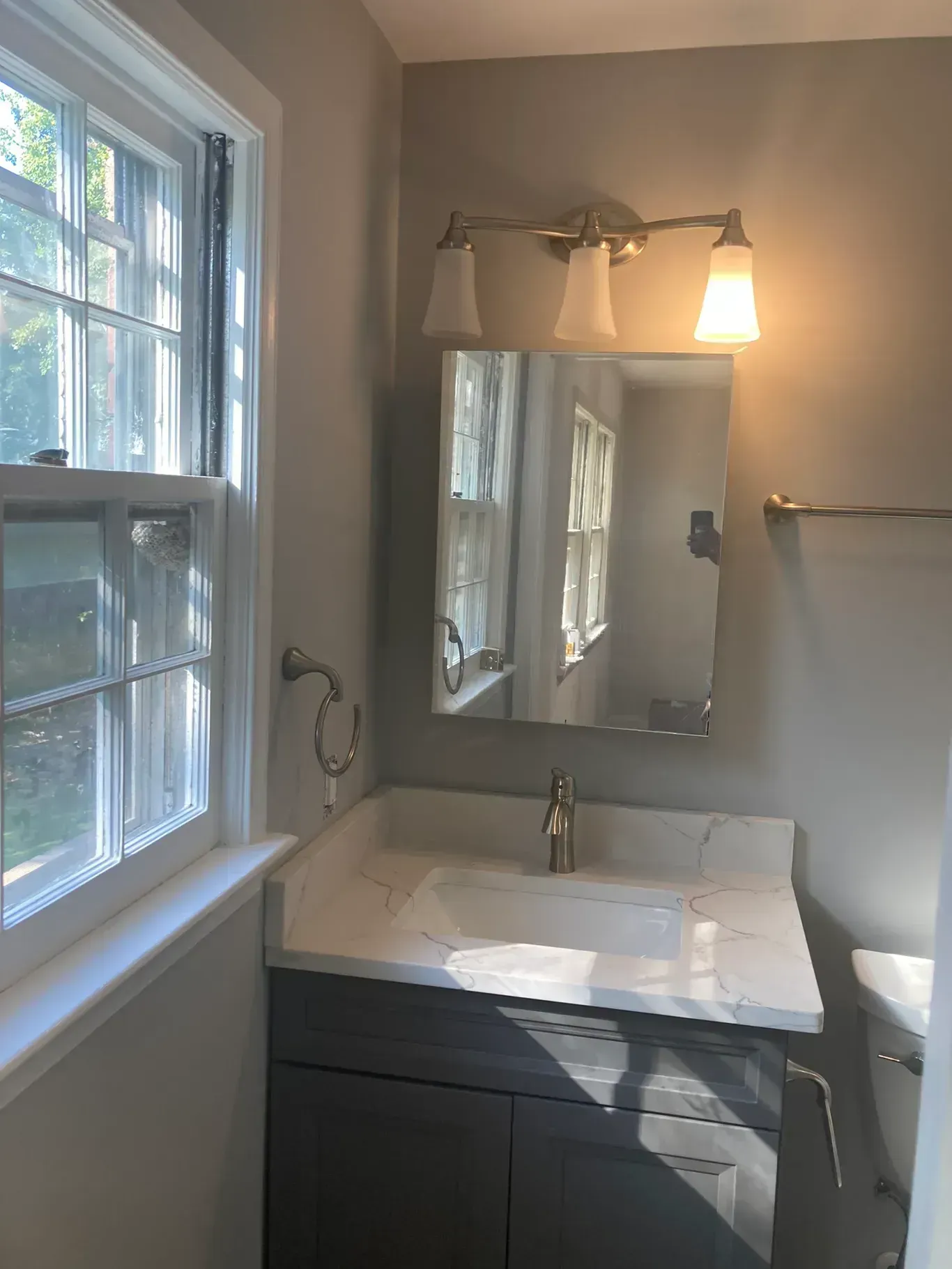 A bathroom with a sink a mirror and a window