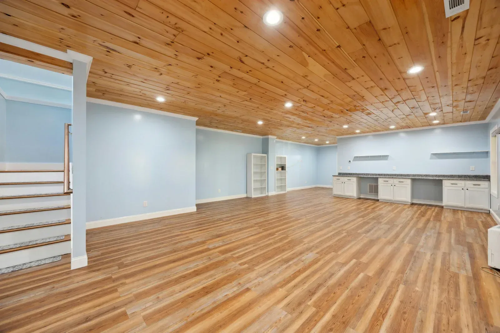 A large empty room with wooden floors and a wooden ceiling.