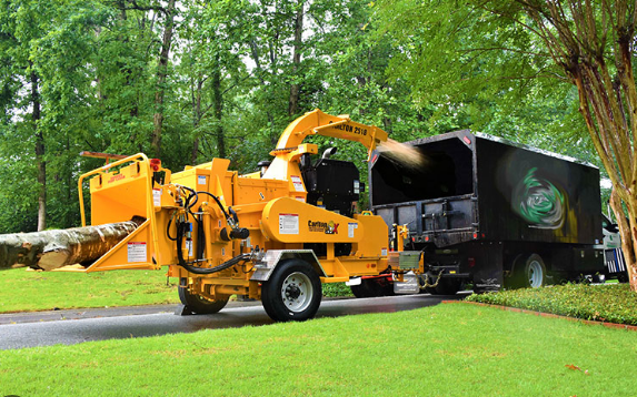 Wood mulching and chipping machine sprays debris