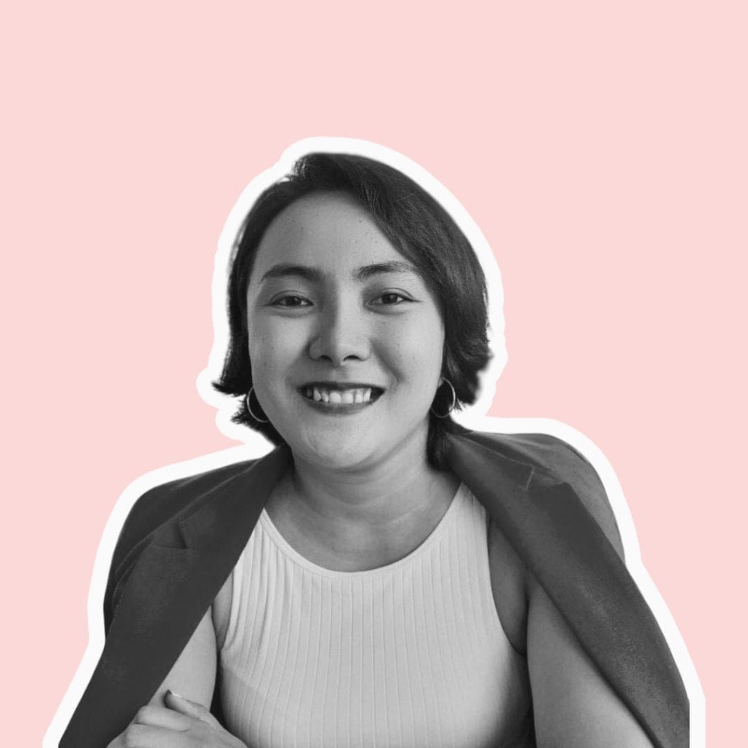 Royce Ortega with a blazer draped over their shoulders against a light pink background.