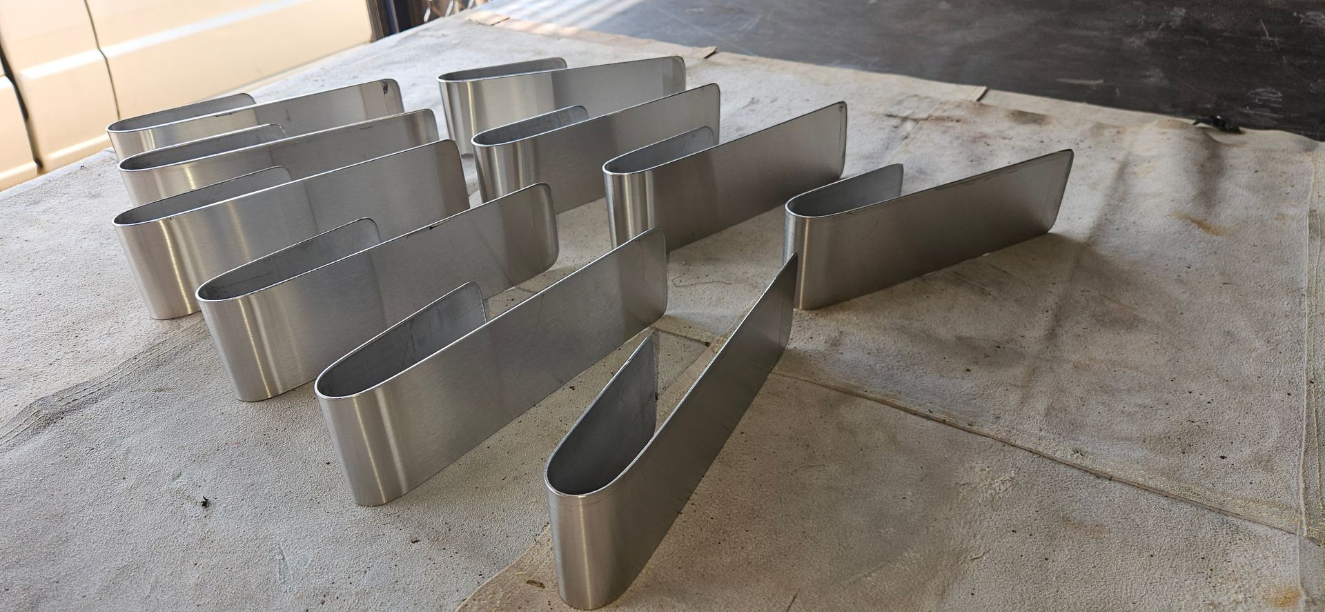 Rows of shiny metal barriers arranged on a concrete floor in a bright indoor space