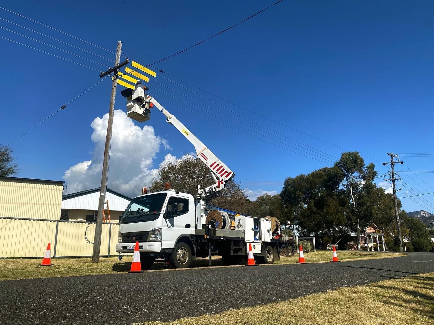 Utility Truck With Raised Bucket ARM Working Near Road Cones — Diverse Power In Berkeley Vale, NSW