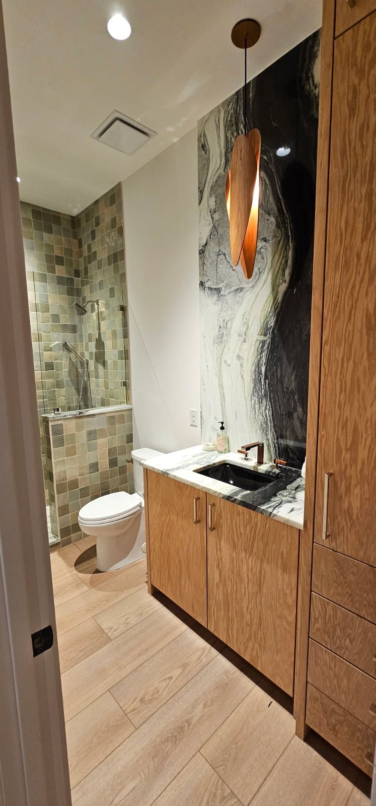 A bathroom with a toilet , sink , and shower.