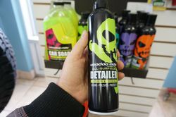 Une personne tient une bouteille noire Voodoo Ride avec un logo tête de mort dans un magasin. D'autres bouteilles sont sur une étagère.