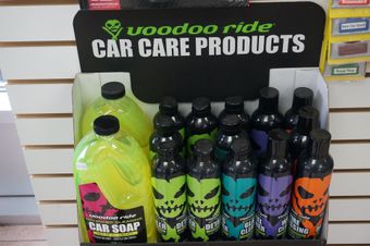 Présentation des produits d'entretien automobile Voodoo Ride avec des bouteilles et une signalétique de différentes couleurs.