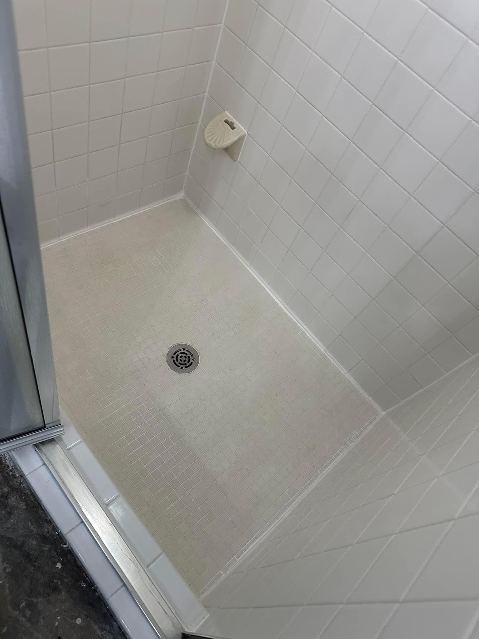 The after picture of a shower restoration. The process for cleaning the shower. Acid to remove hard water mineral deposits. Alkaline solution to remove soap scum, oils, and dirt. Repair grout and recaulk. Color seal shower grout lines.