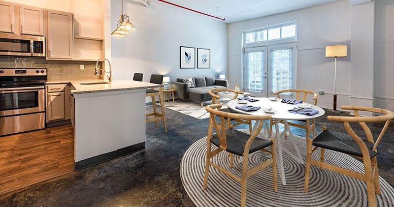 Modern apartment interior: kitchen, dining area, and living room. Neutral colors, natural light, and contemporary furnishings.
