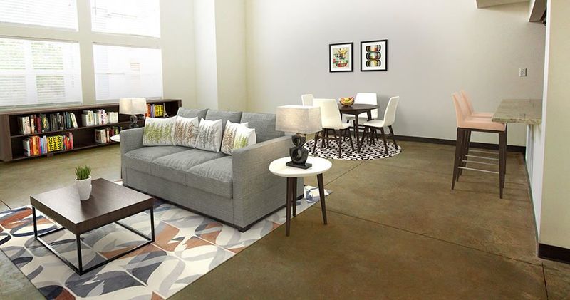Living room with sofa, coffee table, bookshelves, and dining area.