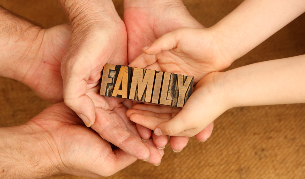 A family is holding the word family in their hands.