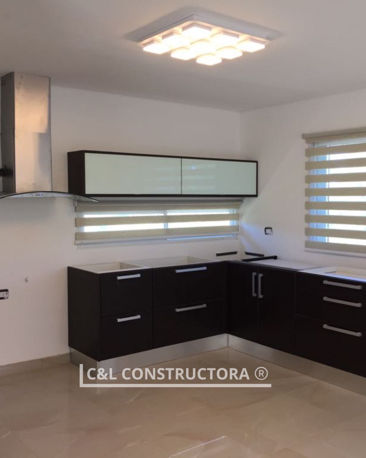 Gabinetes de cocina de color marrón oscuro con una campana extractora de acero inoxidable
