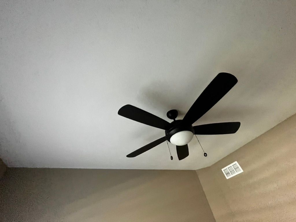 A ceiling fan is hanging from the ceiling of a room