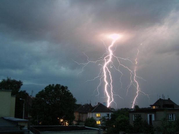 Lightning strikes in the sky over a city at night