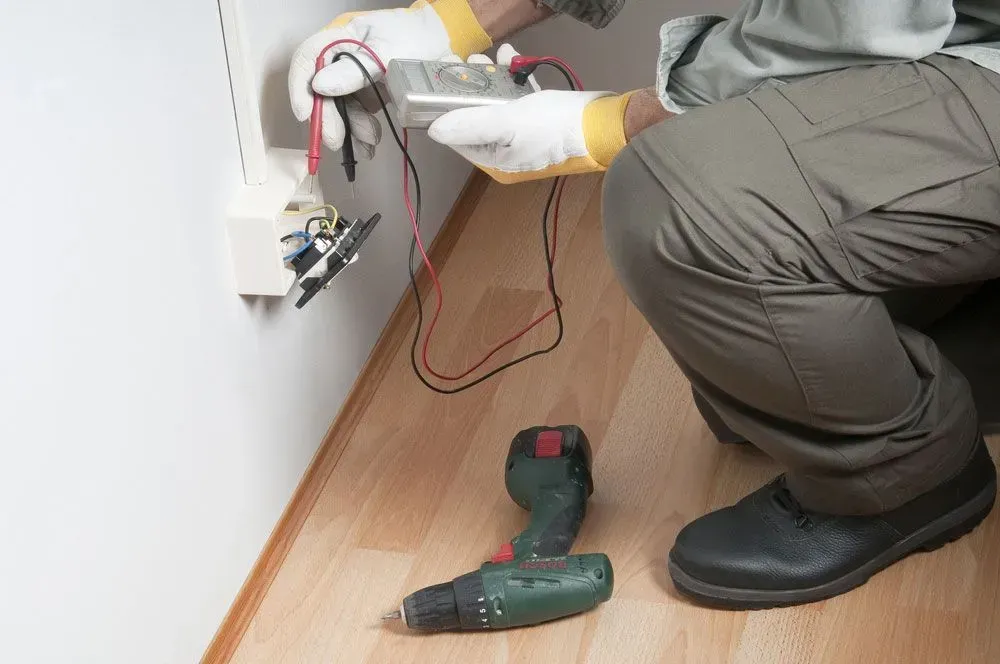 A Person in Work Gloves Uses a Multimeter to Test Wires — CH Electrics in Rockhampton, QLD