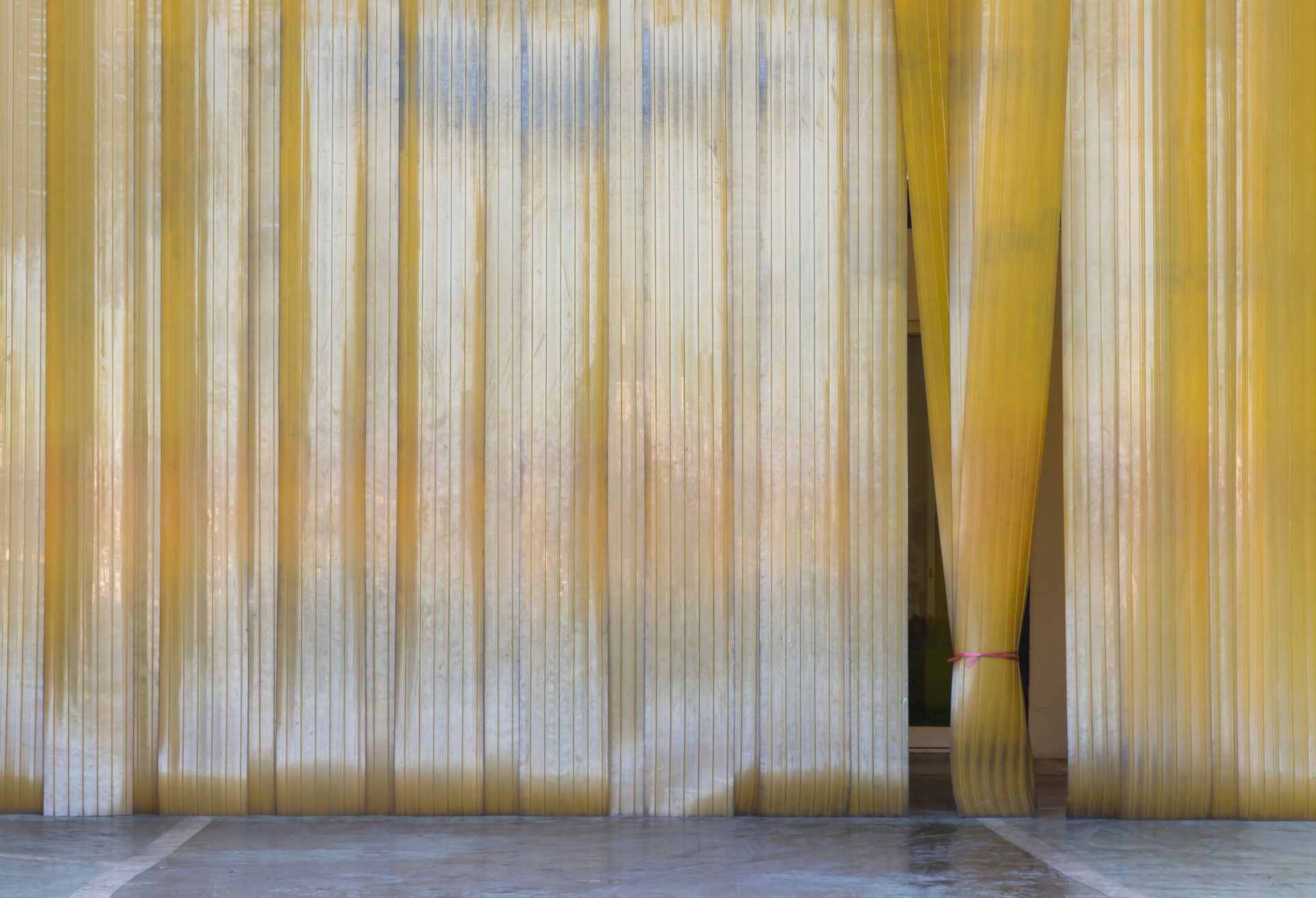 A yellow curtain is hanging on a wall in a room. A yellow curtain is hanging on a wall in a room.