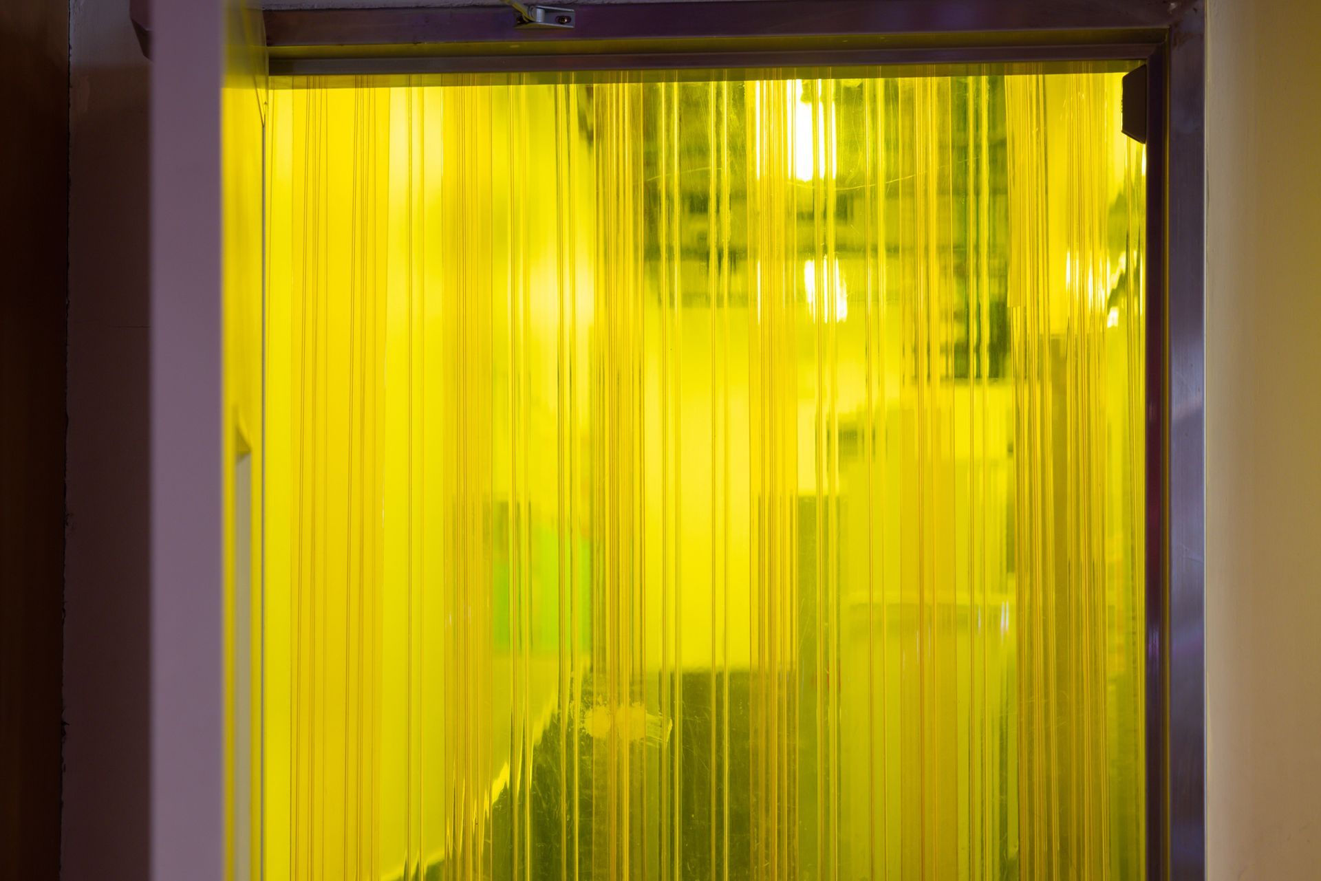 A yellow curtain is hanging on a window in a room. A yellow curtain is hanging on a window in a room.