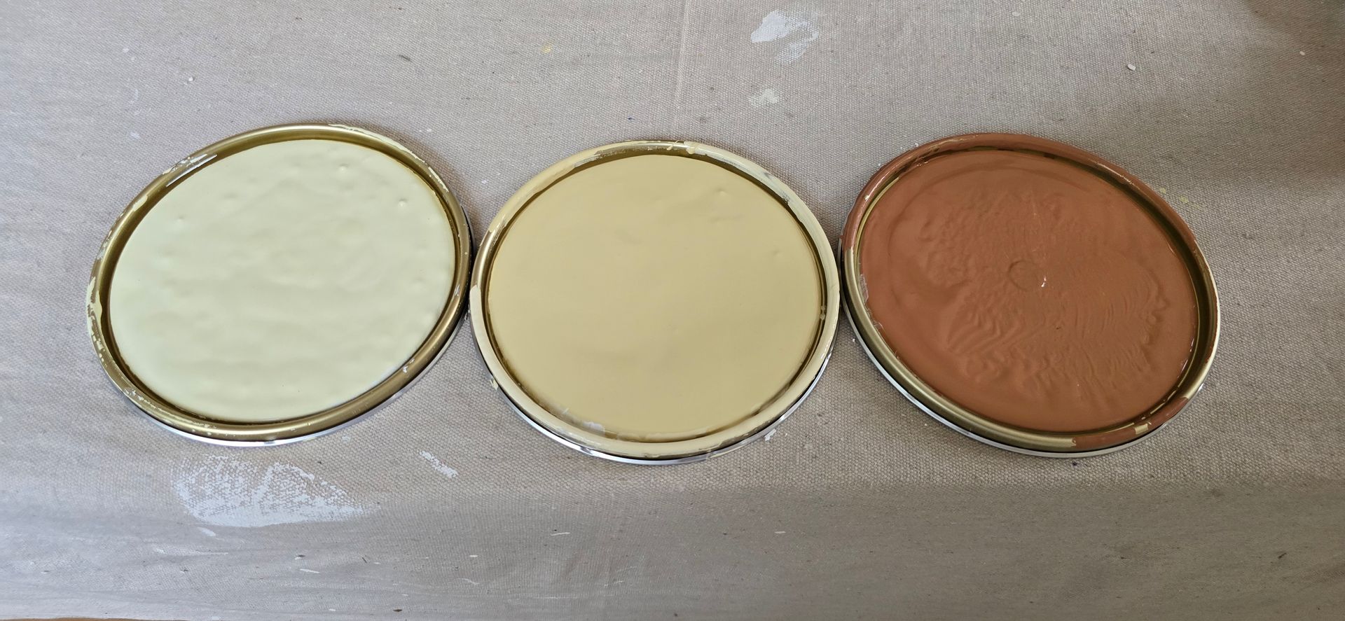 Three paint can lids with different colours— JAX Painting Services in Central Coast, NSW