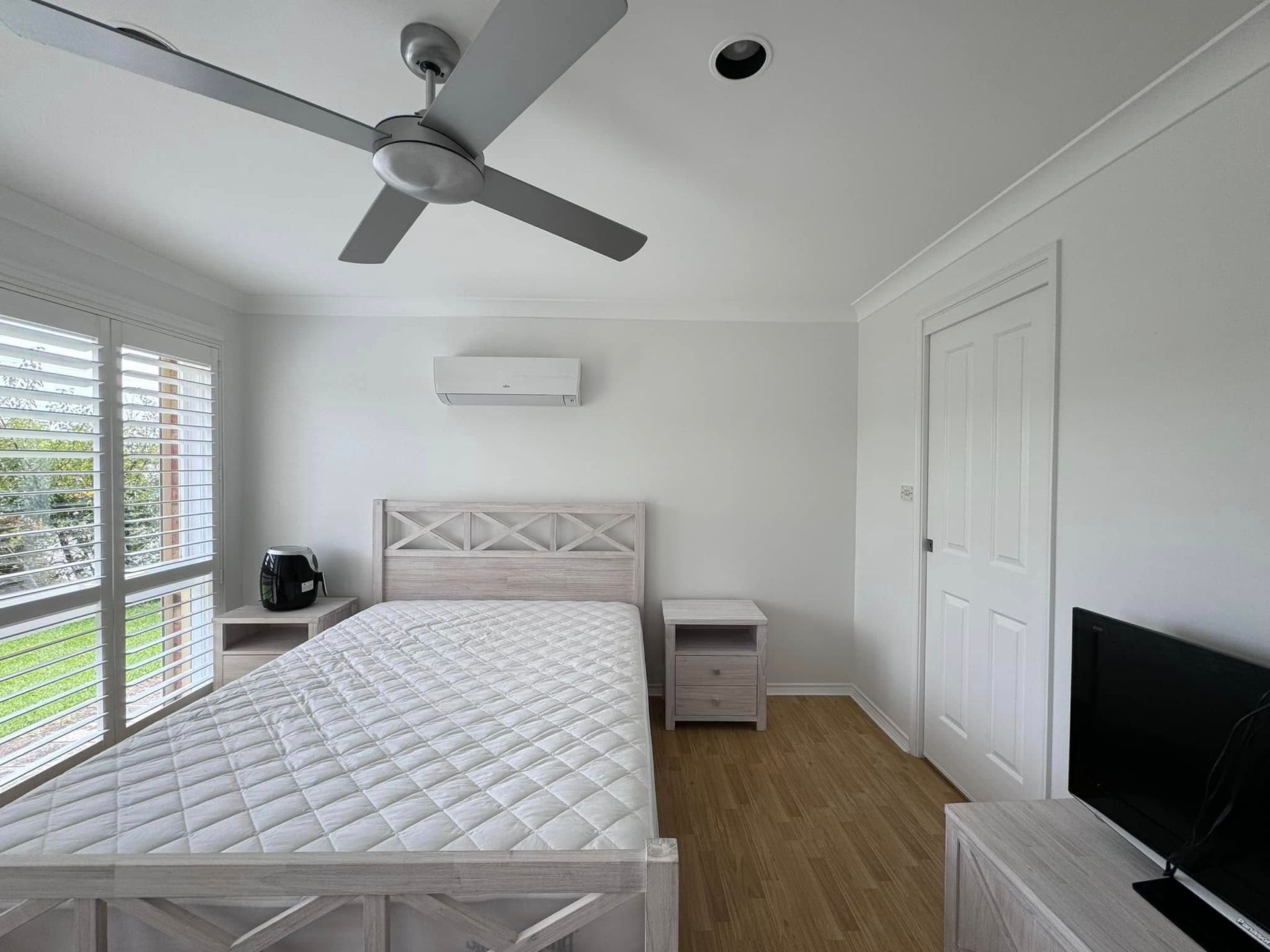 An Empty Room With a Ceiling Fan and a Window — JAX Painting Services in Central Coast, NSW
