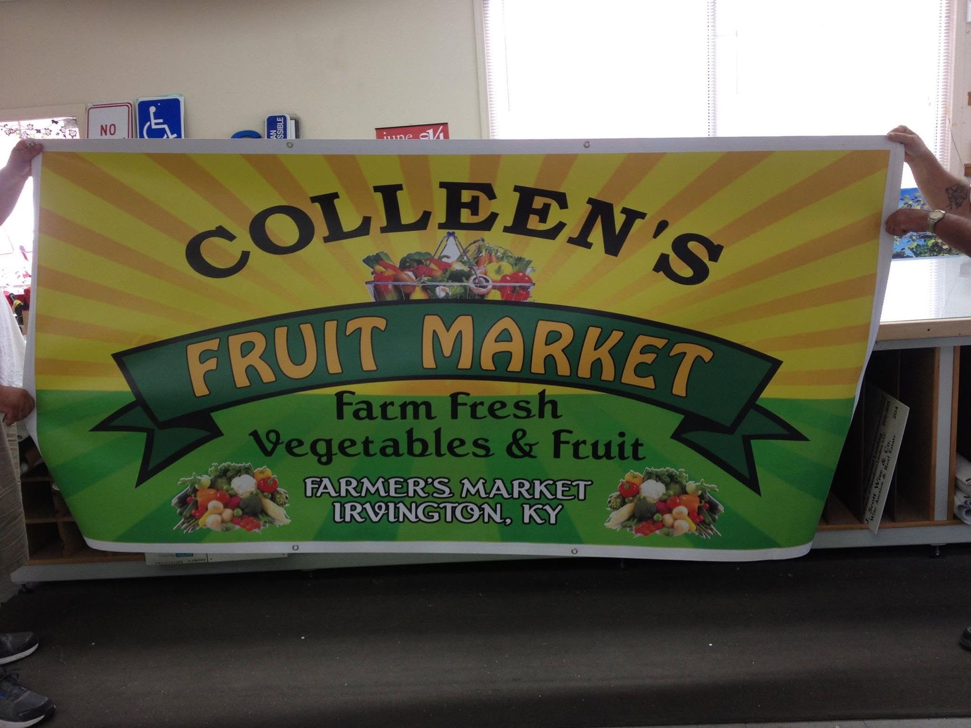 Colorful Colleen’s Fruit Market banner advertising fresh vegetables and fruit in a store. Colorful Colleen’s Fruit Market banner advertising fresh vegetables and fruit in a store.