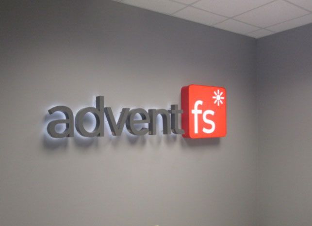 Adventfs logo on a gray wall, with gray and red lettering.