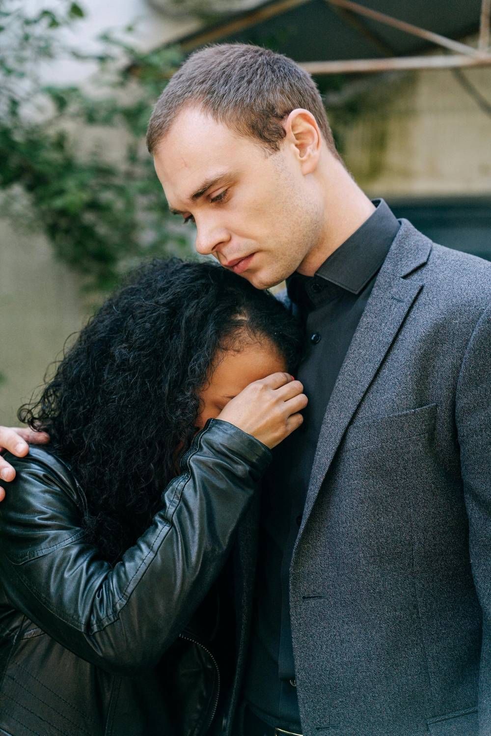 Man in a suit standing quietly in mourning at a funeral