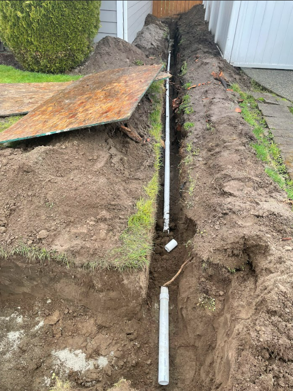 A pipe is being installed in a hole in the ground.