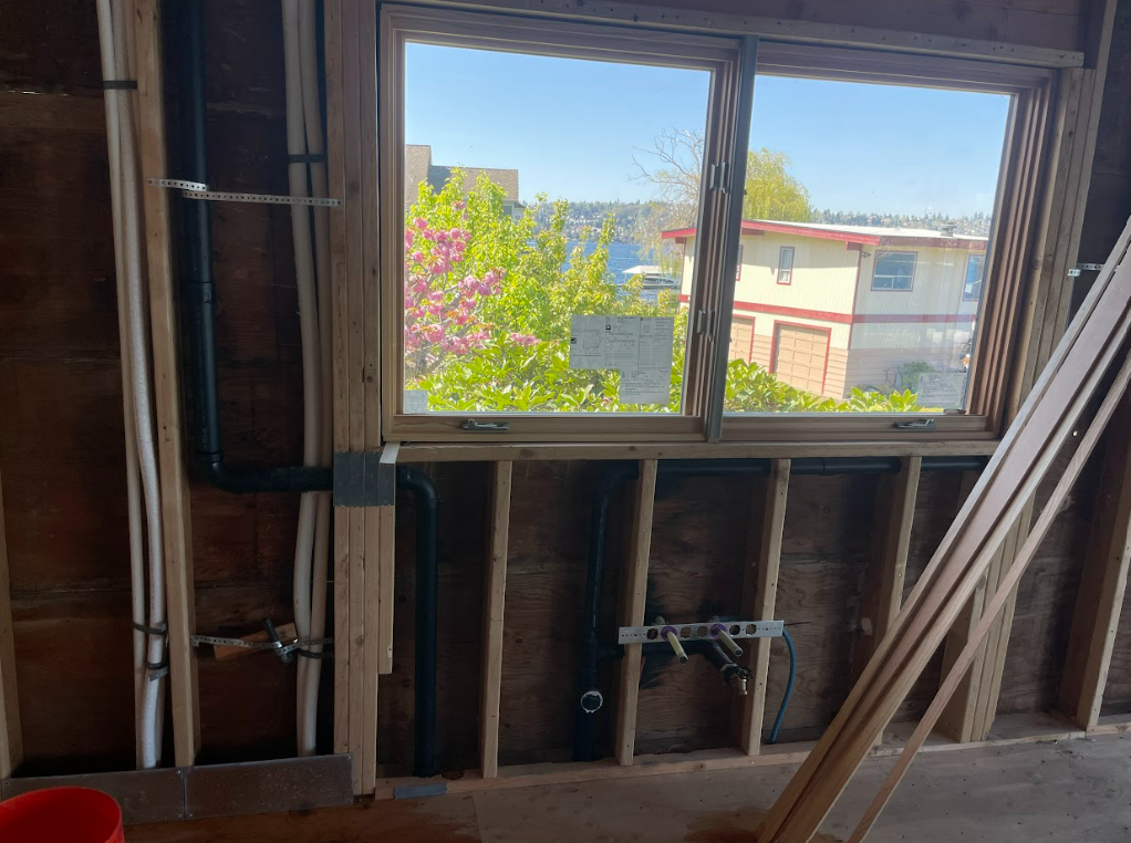 A window in a building under construction with a view of a city.