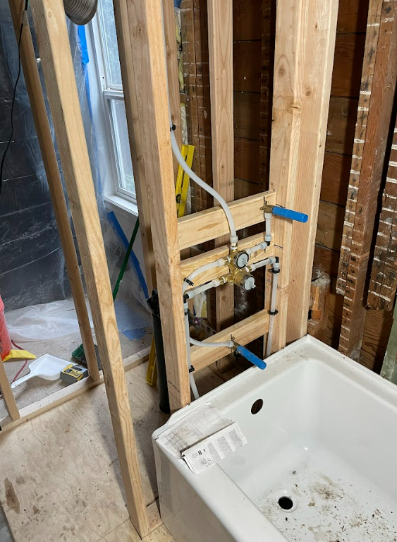 A bathtub is sitting in a bathroom under construction.