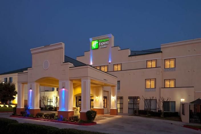 Hotel entrance at dusk with lit columns and glowing windows