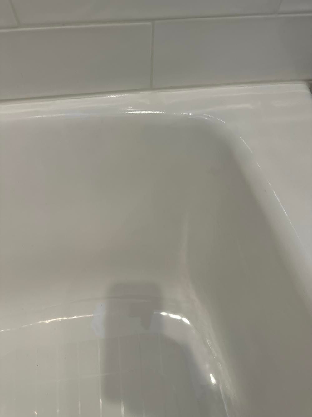 White bathtub with a ceramic tile border.