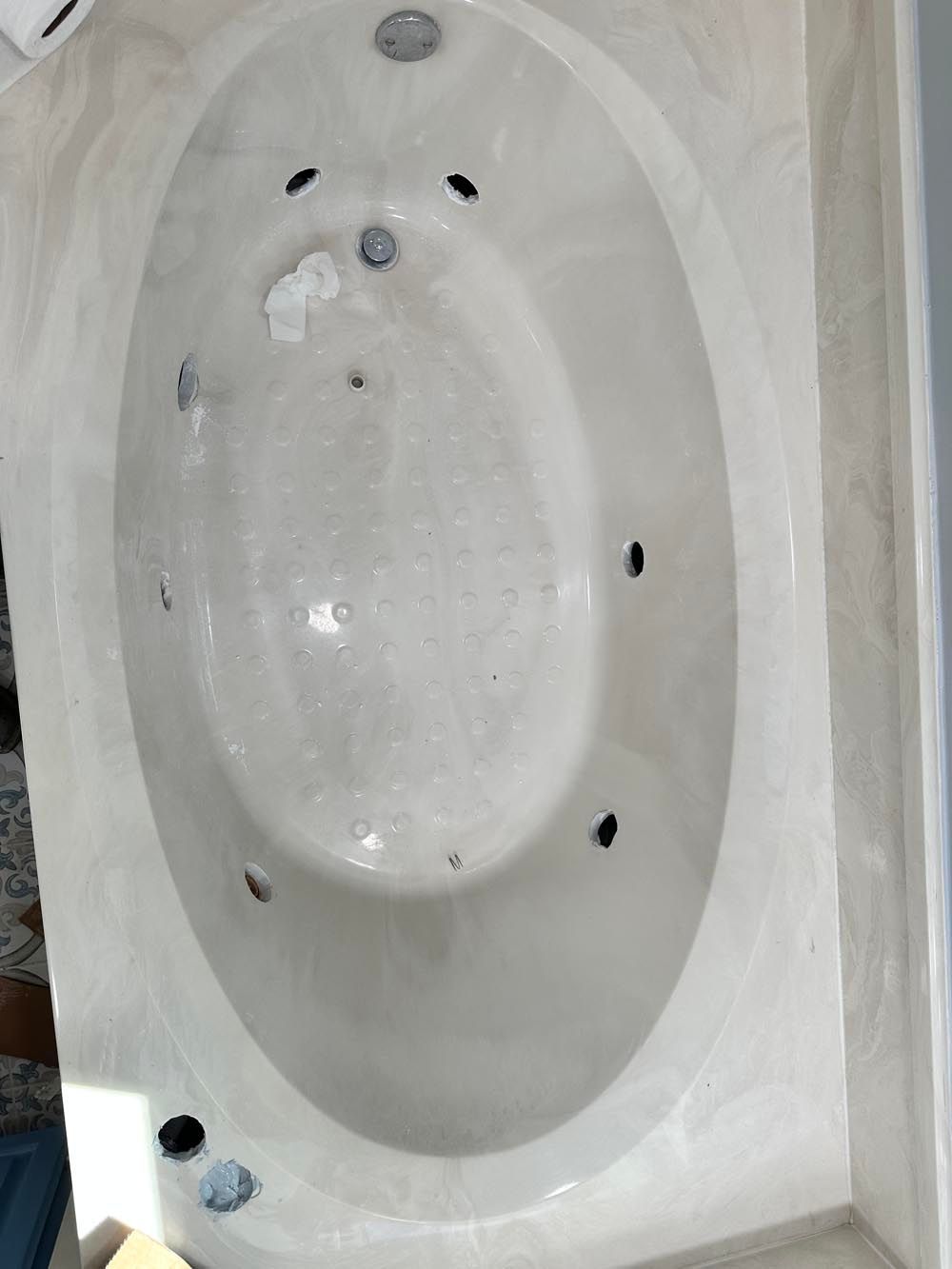 Oval jacuzzi bathtub with jets, in a bathroom.