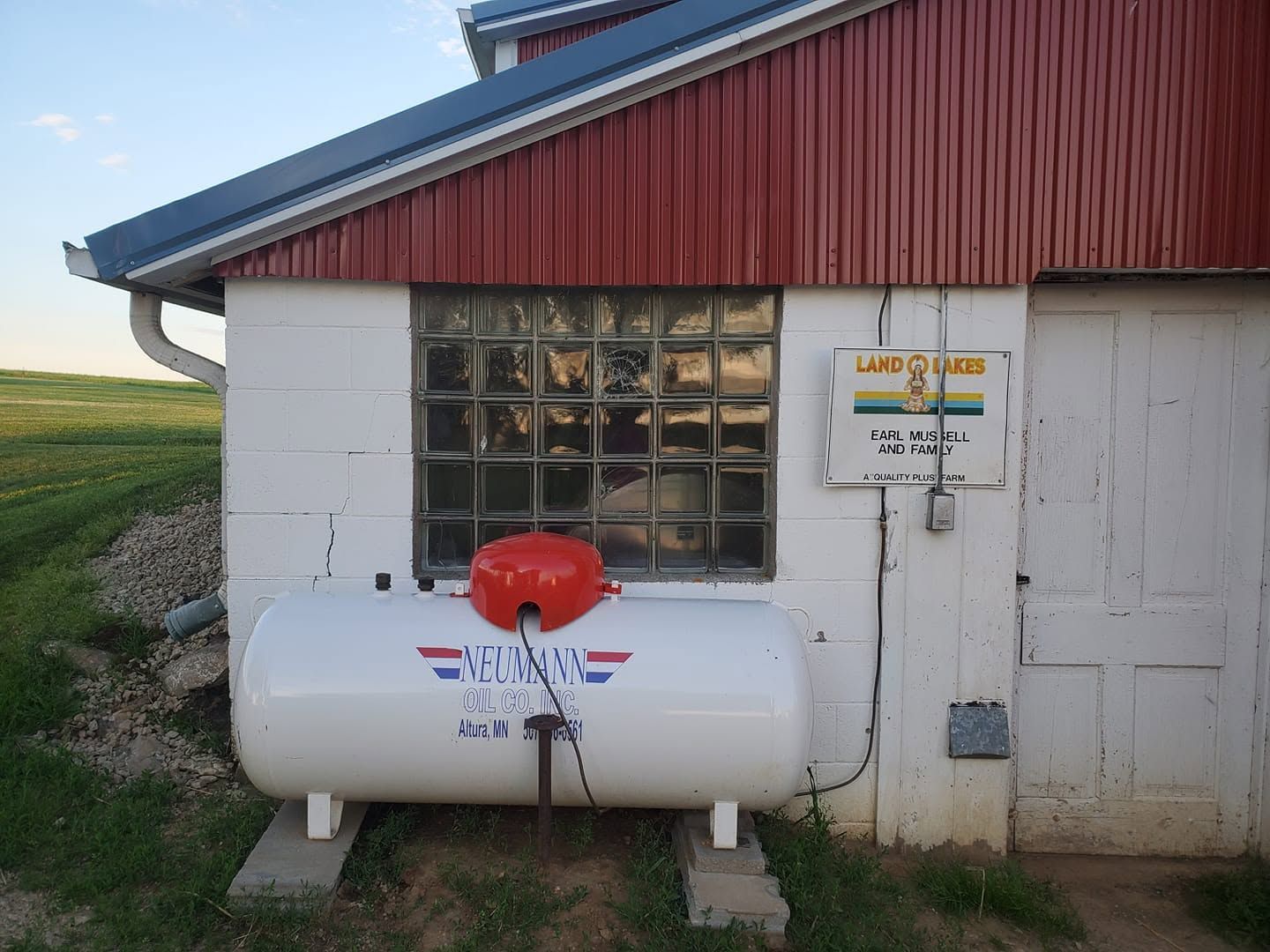 Neumann Oil Company tank hooked up to a Land O' Lakes building.