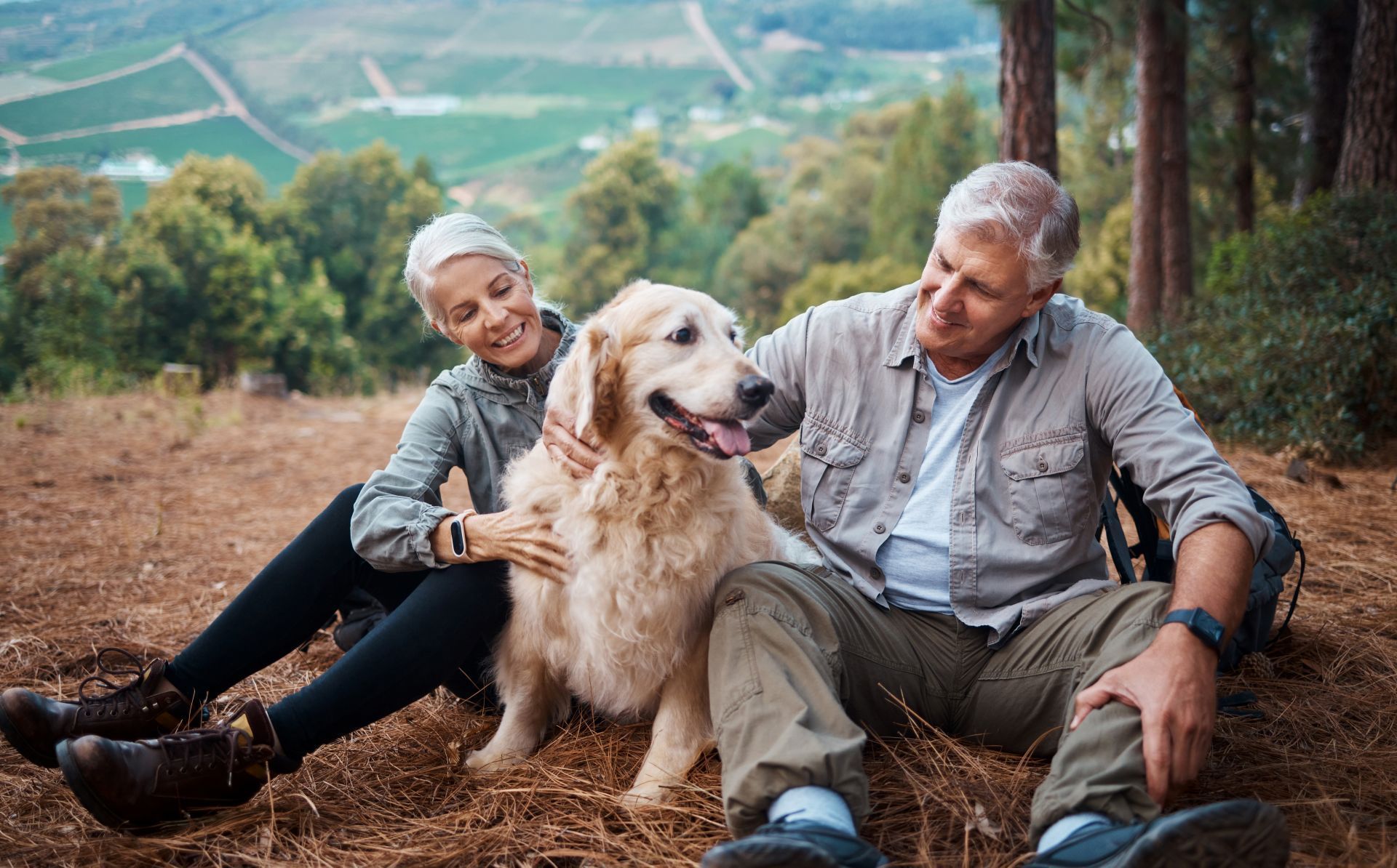 A man and a woman are holding a dog 's paw in their hands.