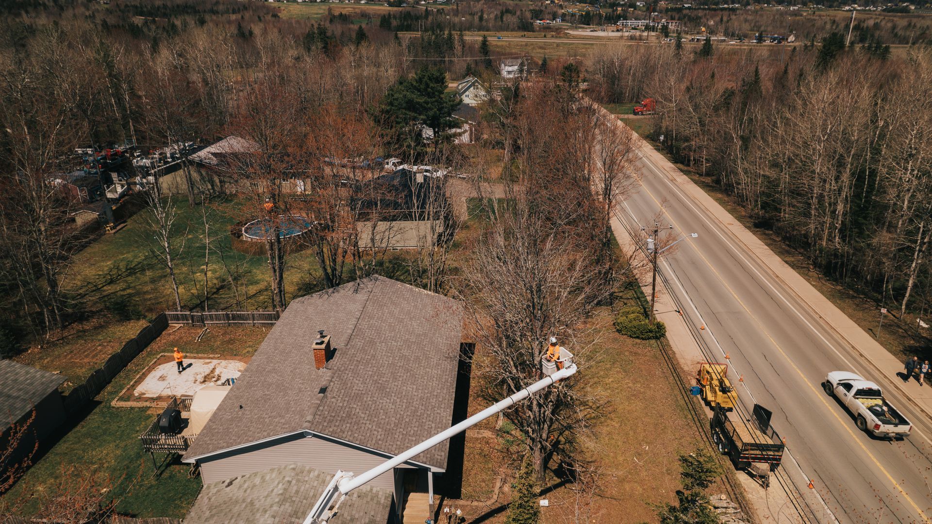 An aerial view of a house with a crane in front of it.