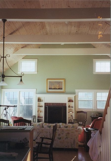 A living room with green walls and a fireplace