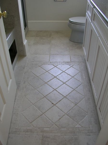 A bathroom with a tiled floor and a toilet