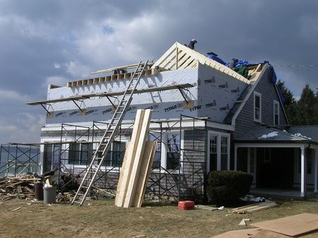A house is being remodeled with a roof being installed