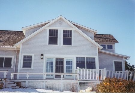 A large white house with a balcony and stairs