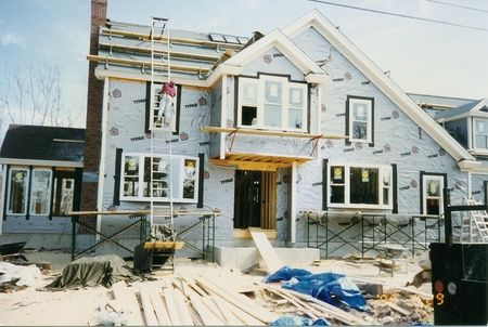 A house that is being built with a lot of windows