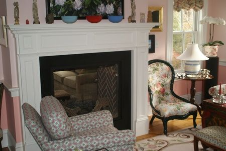 A living room with a fireplace and chairs